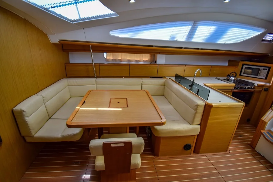 Saloon table in sailing yacht Jeanneau Sun Odyssey 50DS Eleven for charter in Marmaris in Turkey